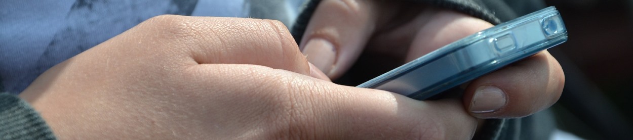 Close-up photo of a child's hands using a cell phone